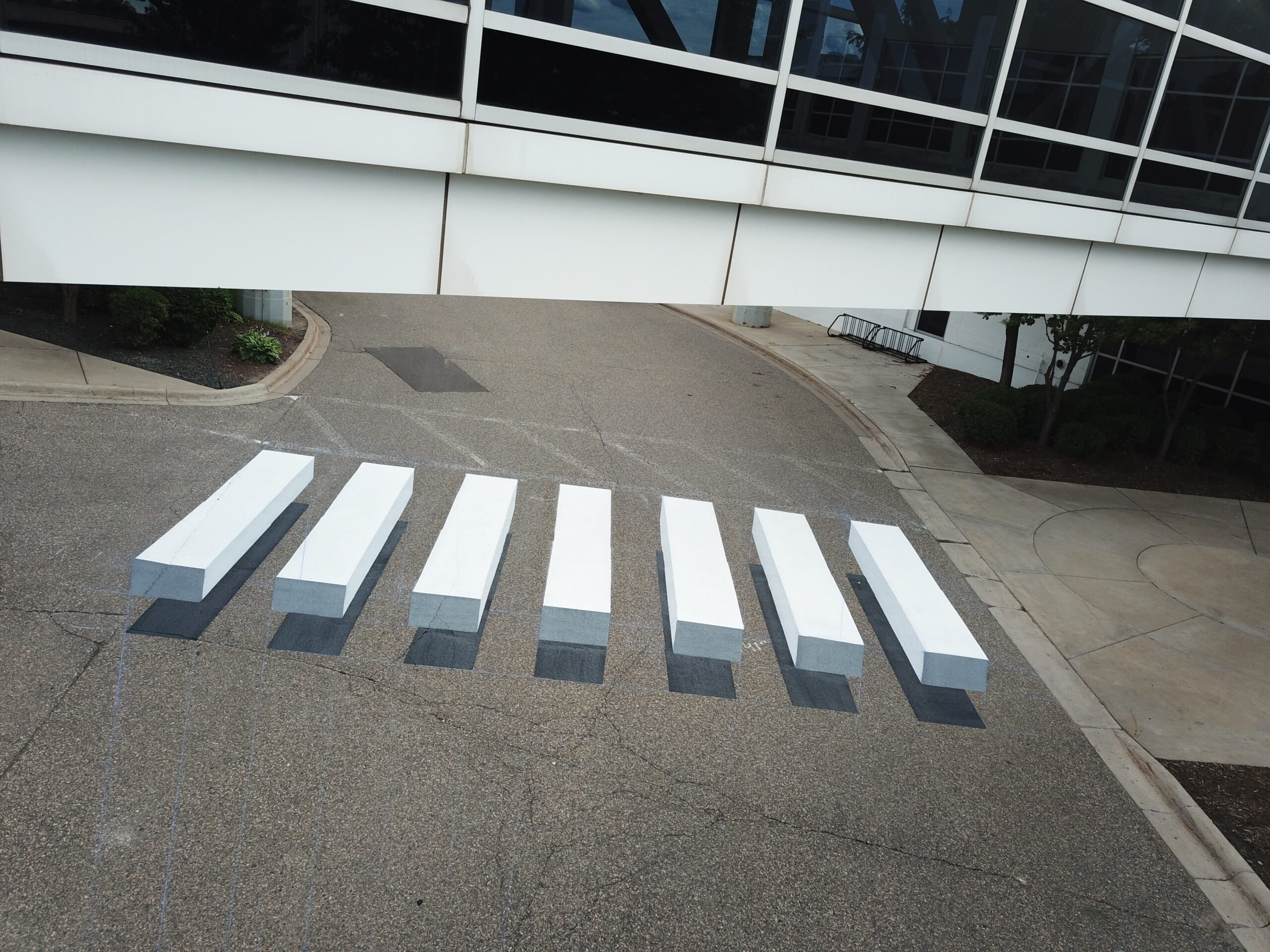Dimensional crosswalk pavement painting beneath a glass skyway by Schroeder Striping